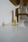 Small bottle of essential oil on a bathroom counter with a blurred background